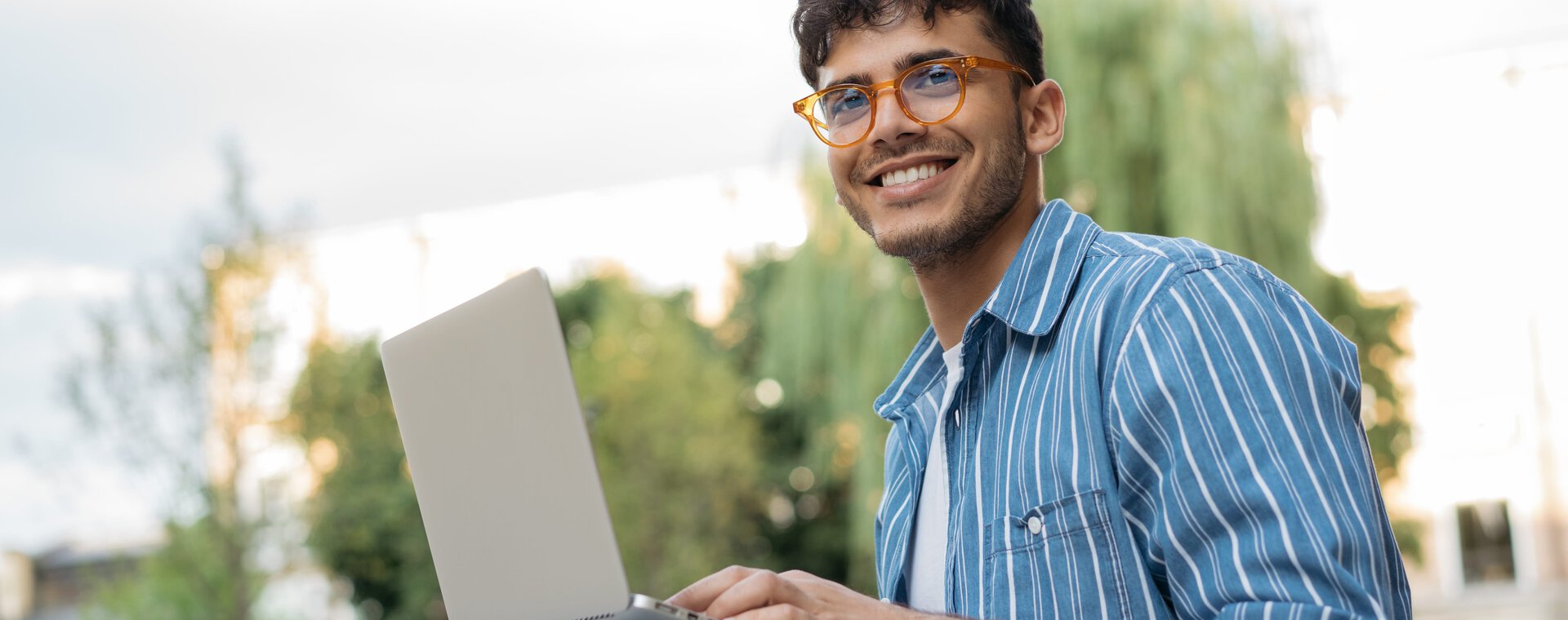 Junger Mann mit Brille am Laptop